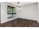 Dining room features dark floors, a modern chandelier, and large window overlooking the backyard at 7378 Winery Ln, Charlotte, NC 28227