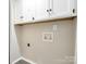 Laundry room with white upper cabinets and hookups for a washer and dryer at 7378 Winery Ln, Charlotte, NC 28227