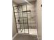 Bathroom shower featuring neutral tile and a modern black-framed glass enclosure at 7378 Winery Ln, Charlotte, NC 28227
