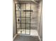 Bathroom shower featuring neutral tile and a modern black-framed glass enclosure at 7378 Winery Ln, Charlotte, NC 28227