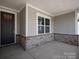 Inviting front porch featuring brick accents and ample space for outdoor seating at 4679 Hopsack Dr # Cal0108, Indian Trail, NC 28079