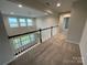 Well-lit upper hallway with carpet and a view through large windows to the outdoors at 4679 Hopsack Dr # Cal0108, Indian Trail, NC 28079