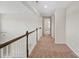 Upstairs hallway featuring neutral carpet, a wood railing, and white walls at 4679 Hopsack Dr # Cal0108, Indian Trail, NC 28079