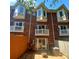 Brick townhome backyard with bay windows, small patio, and privacy fence at 1125 Kurt Ct, Charlotte, NC 28209