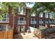 Brick townhomes overlook a fenced backyard with a small patio and landscaping at 1125 Kurt Ct, Charlotte, NC 28209