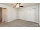 A bedroom with a neutral color palette, ceiling fan, double closets, and an attached bathroom at 1125 Kurt Ct, Charlotte, NC 28209