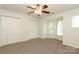 A simple bedroom with a ceiling fan, a large window, and a double closet is move-in ready at 1125 Kurt Ct, Charlotte, NC 28209