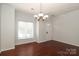 Bright dining room featuring hardwood floors, a chandelier, and a window at 1125 Kurt Ct, Charlotte, NC 28209