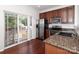 Kitchen featuring stainless steel appliances, granite countertops, wooden cabinetry, and sliding glass doors at 1125 Kurt Ct, Charlotte, NC 28209