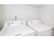 Bright laundry room showing two white washing machines and a white wire shelf at 1125 Kurt Ct, Charlotte, NC 28209