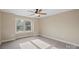 Neutral bedroom featuring a ceiling fan and a window allowing natural light at 4023 Randolph Rd, Charlotte, NC 28211