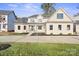 Beautiful new construction home with a lush lawn, dark mulch beds, and a light beige stucco exterior at 4023 Randolph Rd, Charlotte, NC 28211