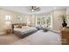 Spacious bedroom with a large window, ceiling fan, and comfortable seating area at 4023 Randolph Rd, Charlotte, NC 28211