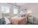 A bedroom with pink walls and a white bed with unicorn decorations and large windows at 420 Serenity Cir, Cramerton, NC 28032