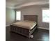 Serene bedroom with tray ceiling, dark wood floors, neutral walls, and abundant natural light from large windows at 2044 Sweet William Dr, Harrisburg, NC 28075