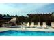 Community pool with lounge chairs, an outdoor fireplace, an umbrella, and a wooden pergola at 833 A Wynnshire Dr # 56, Hickory, NC 28601