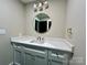 Bathroom featuring a marble countertop, bronze faucet, a bronze-framed round mirror, and a towel hook at 416 Plantation Way, Mount Gilead, NC 27306