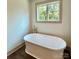 Bathroom featuring a luxurious soaking tub with wood-look floors and a natural view through the window at 416 Plantation Way, Mount Gilead, NC 27306