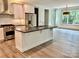 Open-concept kitchen featuring stainless steel appliances, an island with seating and backyard views at 416 Plantation Way, Mount Gilead, NC 27306