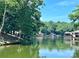 Picturesque lake view surrounded by lush greenery and calm waters with a glimpse of boat docks at 416 Plantation Way, Mount Gilead, NC 27306