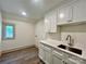 Laundry room featuring shaker cabinets, a marble countertop, bronze faucet, and a window view at 416 Plantation Way, Mount Gilead, NC 27306