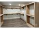 Spacious walk-in closet ready for customization with wood-look floors, shelving, and clothing racks at 416 Plantation Way, Mount Gilead, NC 27306