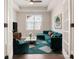 Inviting living room with stylish teal sofa, bright rug and window providing natural light at 831 B Wynnshire Dr # 60, Hickory, NC 28601