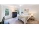 Bright bedroom with neutral tones, featuring two windows, and a decorative chandelier and furnishings at 2907 Meherrin Ct, Waxhaw, NC 28173