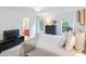 Bright bedroom with neutral tones, featuring two windows, an en suite bathroom and modern TV console at 2907 Meherrin Ct, Waxhaw, NC 28173