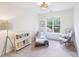 Bright bedroom with neutral tones, featuring a window, rocking chair and charming bookshelf at 2907 Meherrin Ct, Waxhaw, NC 28173