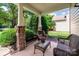 Inviting covered front porch featuring stone pillars and a charming wicker furniture set at 2907 Meherrin Ct, Waxhaw, NC 28173