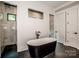 Modern bathroom featuring a standalone tub, walk-in shower and shiplap accent wall at 110 Emmaline Ct, Troutman, NC 28166