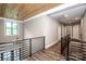 Upstairs hallway with hardwood floors, black metal railings and lots of natural light at 110 Emmaline Ct, Troutman, NC 28166