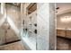 Luxurious walk-in shower featuring elegant tile work, rain showerhead and built-in shelving at 110 Emmaline Ct, Troutman, NC 28166