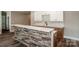 Basement bar area features stone accents, hardwood floors, and white cabinetry at 116 Emmaline Ct, Troutman, NC 28166