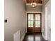 Inviting entryway featuring wood floors, a modern light fixture, and wooden double doors at 116 Emmaline Ct, Troutman, NC 28166
