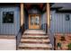 Charming entrance featuring a wooden front door, stone steps, and sleek black railings at 116 Emmaline Ct, Troutman, NC 28166