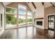 Bright living room features floor to ceiling windows, fireplace, and beautiful wood floors at 116 Emmaline Ct, Troutman, NC 28166