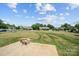 View of backyard from patio shows homes in neighborhood with a large green space at 104 Castle Pines Ln, Statesville, NC 28625