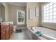 Serene bathroom with a soaking tub, window and neutral decor at 104 Castle Pines Ln, Statesville, NC 28625