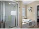 Well-lit bathroom with a glass shower and soaking tub at 104 Castle Pines Ln, Statesville, NC 28625