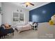 Cozy bedroom area bathed in natural light, enhanced by neutral carpet and tasteful decor at 104 Castle Pines Ln, Statesville, NC 28625