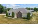 Beautiful single-story home with a well-manicured lawn, stone accents, and mature landscaping at 104 Castle Pines Ln, Statesville, NC 28625