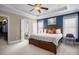 Bright main bedroom with tray ceiling, large bed, and an ensuite bathroom at 104 Castle Pines Ln, Statesville, NC 28625