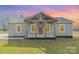Inviting single-story home with a rustic covered porch and neutral siding, set against a colorful sky at 8255 W Nc 10 Hwy, Vale, NC 28168