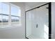 Modern bathroom featuring a black framed glass shower and a double window with a view of the landscape at 133 Armstrong Rd, Belmont, NC 28012