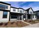 Modern townhome showcases a covered front porch, black window trim, complementary landscaping and stylish architectural design at 133 Armstrong Rd, Belmont, NC 28012