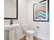 Modern half bath with pedestal sink, toilet, and stylish framed wall art at 133 Armstrong Rd, Belmont, NC 28012