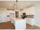 Bright kitchen boasts white cabinets, stainless steel appliances, large island with pendant lighting, and hardwood floors at 133 Armstrong Rd, Belmont, NC 28012