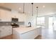 Elegant kitchen features white cabinets, quartz countertops, stainless steel appliances and oversized island with pendant lights at 133 Armstrong Rd, Belmont, NC 28012